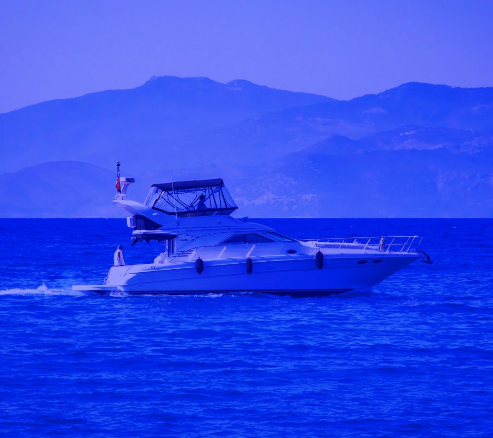 White motor yacht cruising on calm blue sea